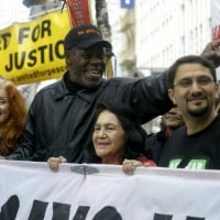 Bonnie Raitt, actor Danny Glover and Dolores Huerta (co-founder of the United Farmworkers Union) greeted marchers as they walked up Market Street in San Francisco's huge anti-war march. - February 17, 2003  © Scott Sommerdorf /San Francisco Chronicle/Corbis